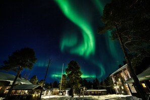 A snow-covered village with buildings and a clear night sky.