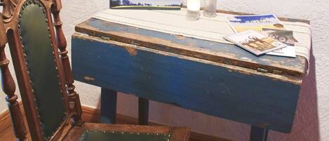 Un escritorio de madera con cubierta azul y una silla con asiento acolchado verde.