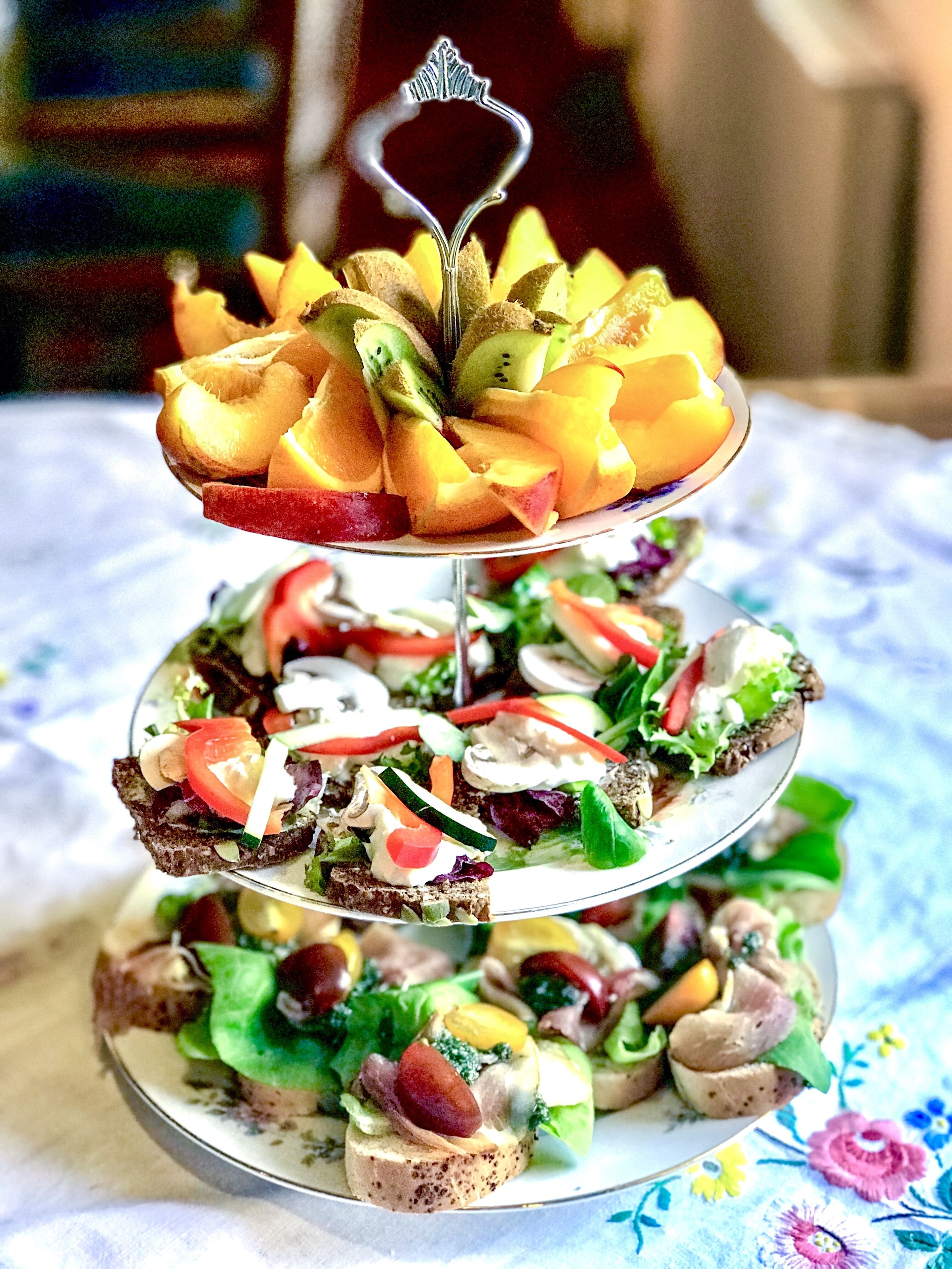 A three-tiered fruit and vegetable platter on a table.