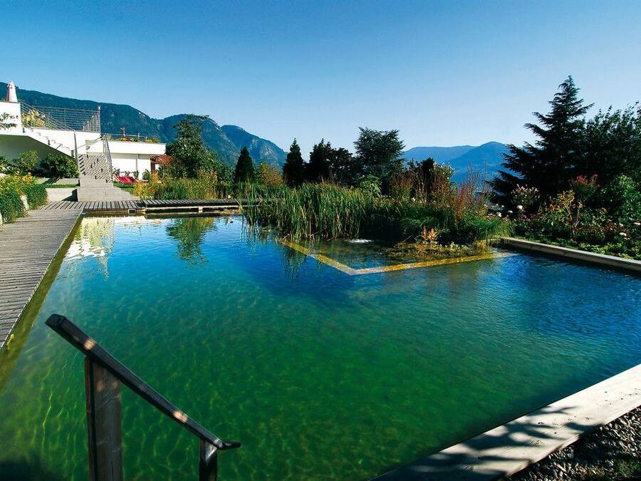 Una piscina cubierta, una piscina al aire libre, tumbonas