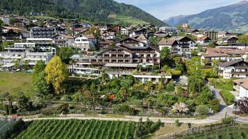 Zona residencial com casas, um edifício grande com vários andares e uma montanha ao fundo.