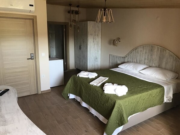 Un dormitorio con cama, armario de madera, lámpara colgante y una puerta.