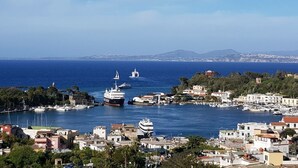 Uma vila costeira com um porto, barcos e edifícios à beira-mar.