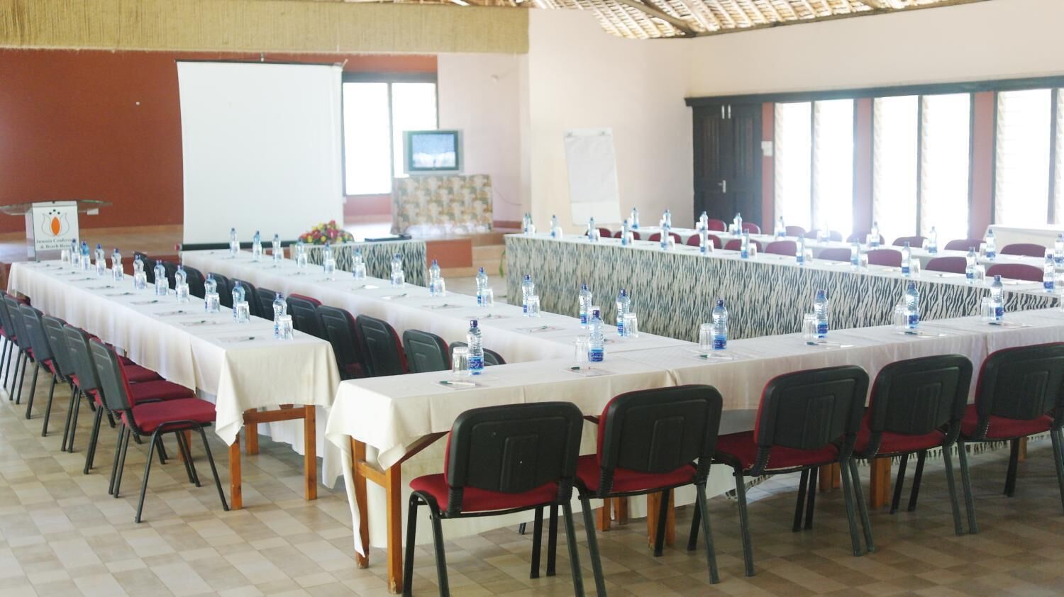 A conference room with long tables, chairs, and water bottles.