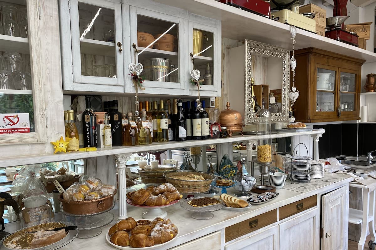 Un comptoir de boulangerie où sont exposés divers produits de boulangerie et une sélection de vins.