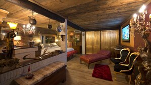 Een knus ingerichte kamer met een bed, een rode bank en een televisie.