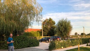 A paved pathway with a parked car and a person walking. - B&B 't Wolvennest (Heuvelland)
