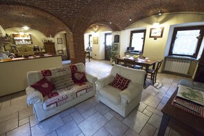 Relax in this inviting living area with a comfortable sofa, dining table, and potted plant.