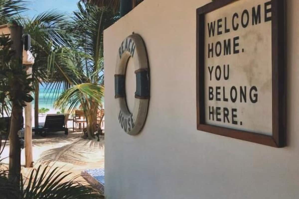 Schild mit Rettungsboje und Strandmotiv an einer Wand.