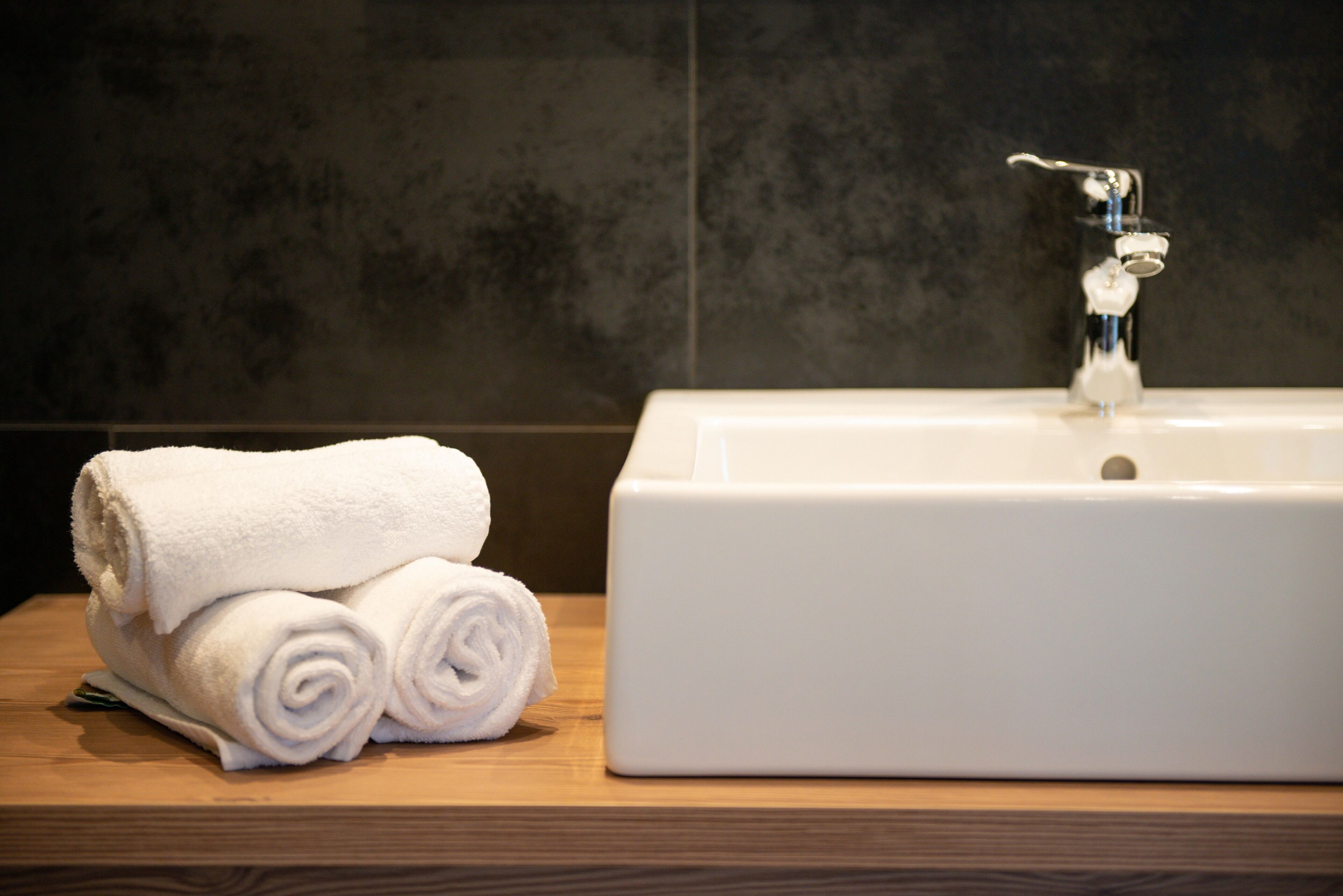A bathroom with a white sink and a wooden countertop.