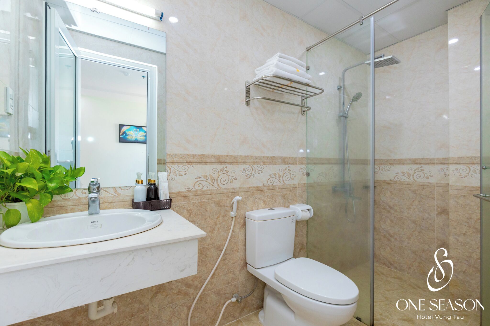 A modern bathroom with a glass shower enclosure, a white sink, and a toilet.