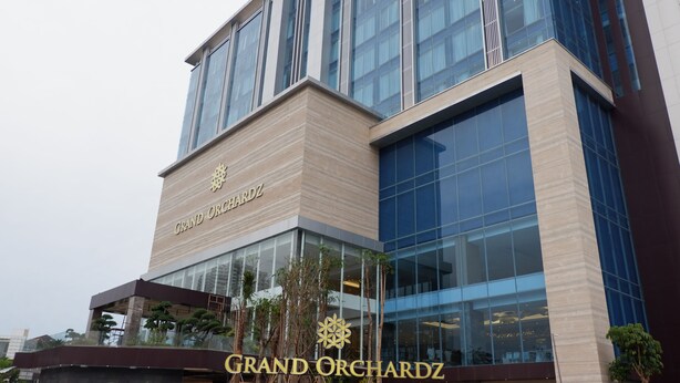 Un bâtiment moderne sur lequel on peut voir en évidence l’enseigne « Grand Orchardz ».