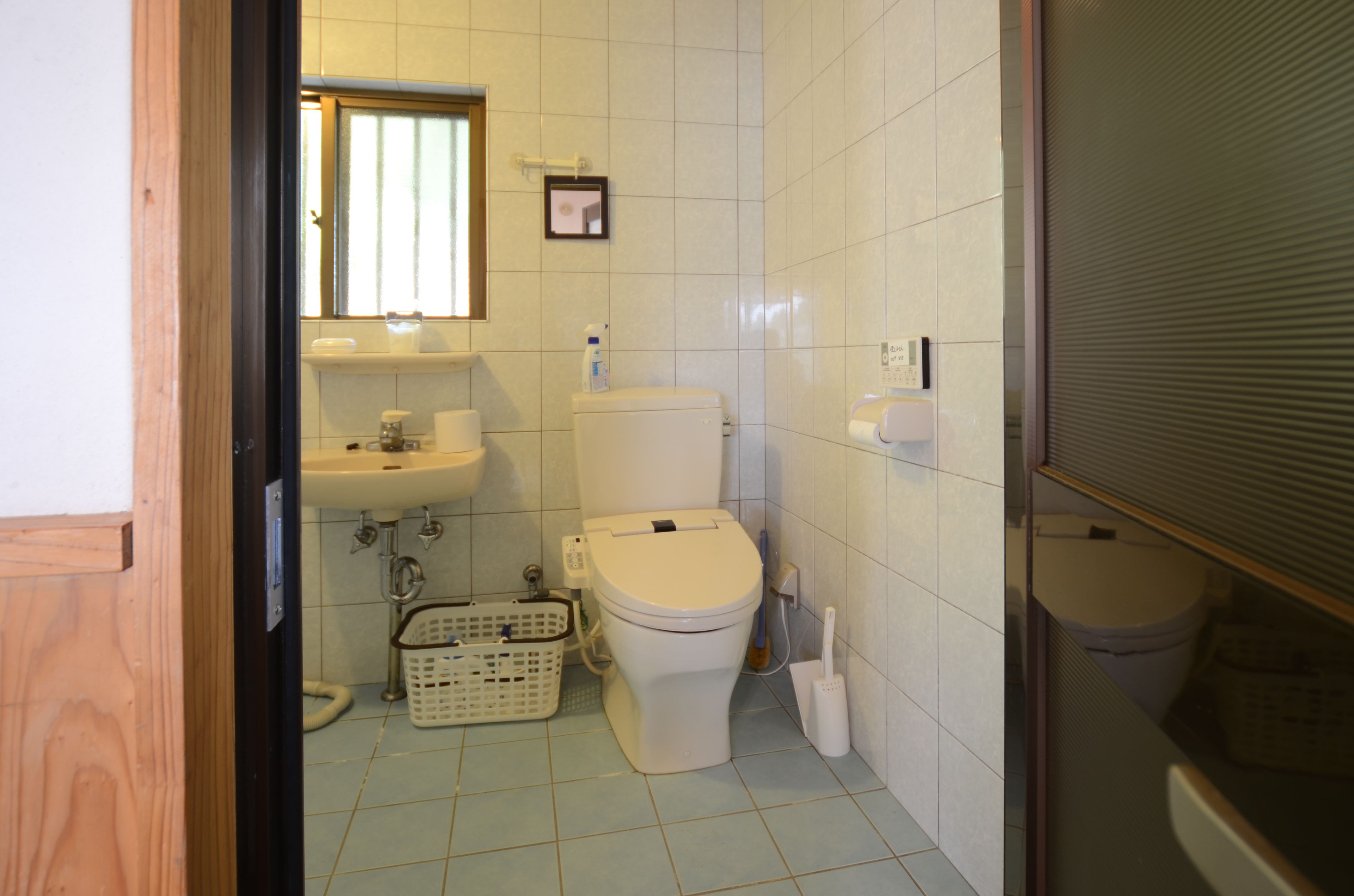 A compact bathroom with a toilet, sink, and a small window.