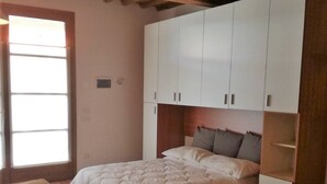 A bedroom with a bed, a desk, and a wardrobe. - Agriturismo Borgo Stella (Montespertoli)