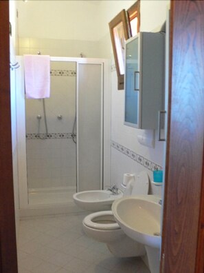 A bathroom with a shower, two toilets, a sink, and a mirror. - Agriturismo Borgo Stella (Montespertoli)