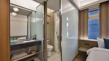 Ein modernes Badezimmer mit Duschkabine aus Glas, Toilette und Waschbecken mit Spiegel.