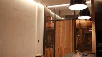 A modern interior with a wooden partition, a desk with a lamp, and a shelf with items.