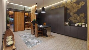 Ein moderner Essbereich mit einem Holztisch, Stühlen, Pendelleuchten und einer Wand mit floralem Dekor.