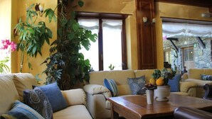 A cozy living room with a sofa set, a wooden coffee table, and a large plant. - Hotel El Rantiner (La Vall de Boi)