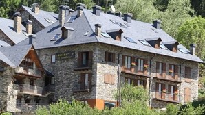 A stone building with multiple balconies, a sign reading "HOTEL EL Rantiner," and a mountainous backdrop. - Hotel El Rantiner (La Vall de Boi)