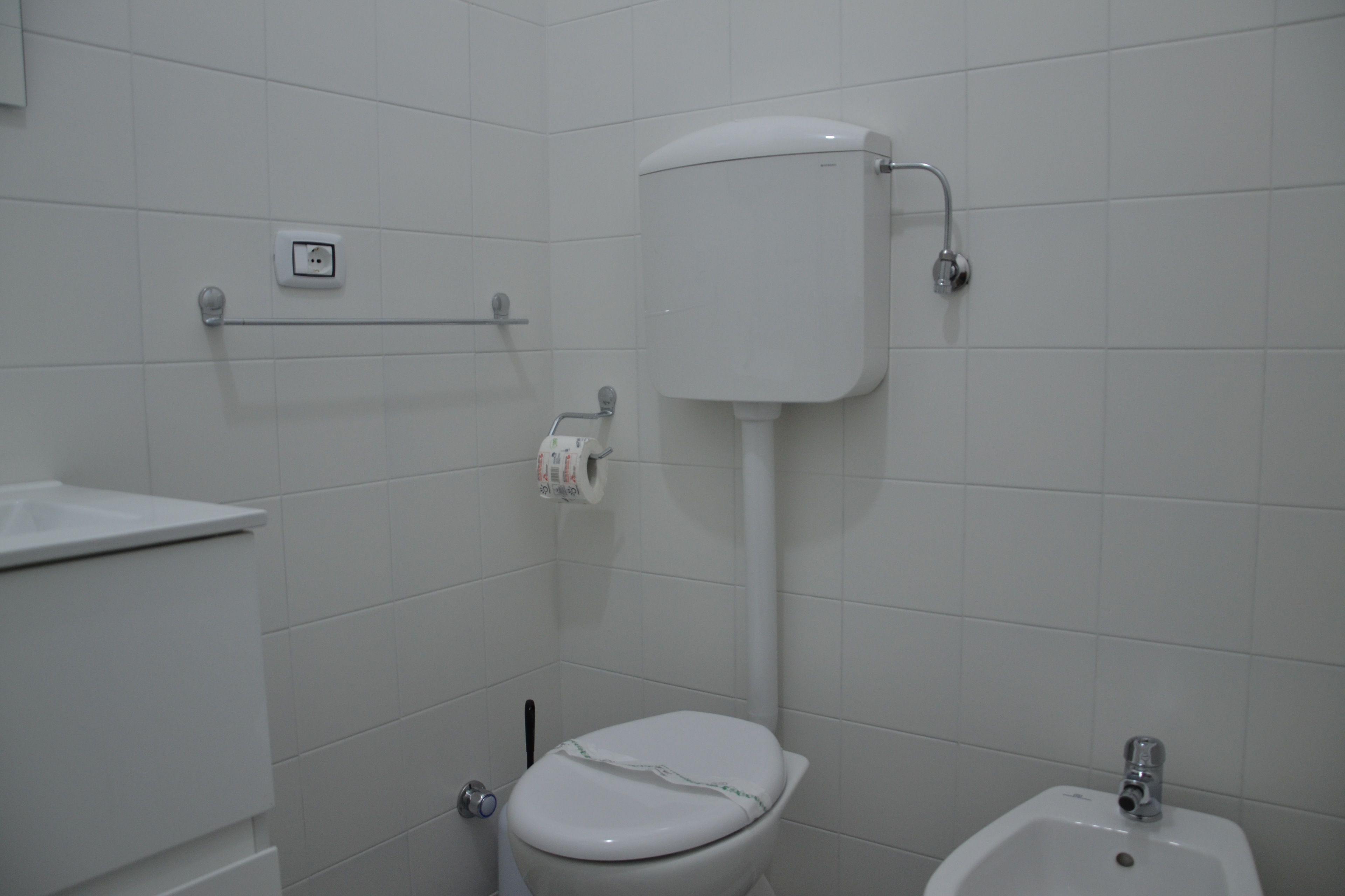Un baño con inodoro, bidé y lavamanos.