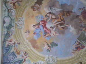 Un techo con un fresco de querubines y ángeles.