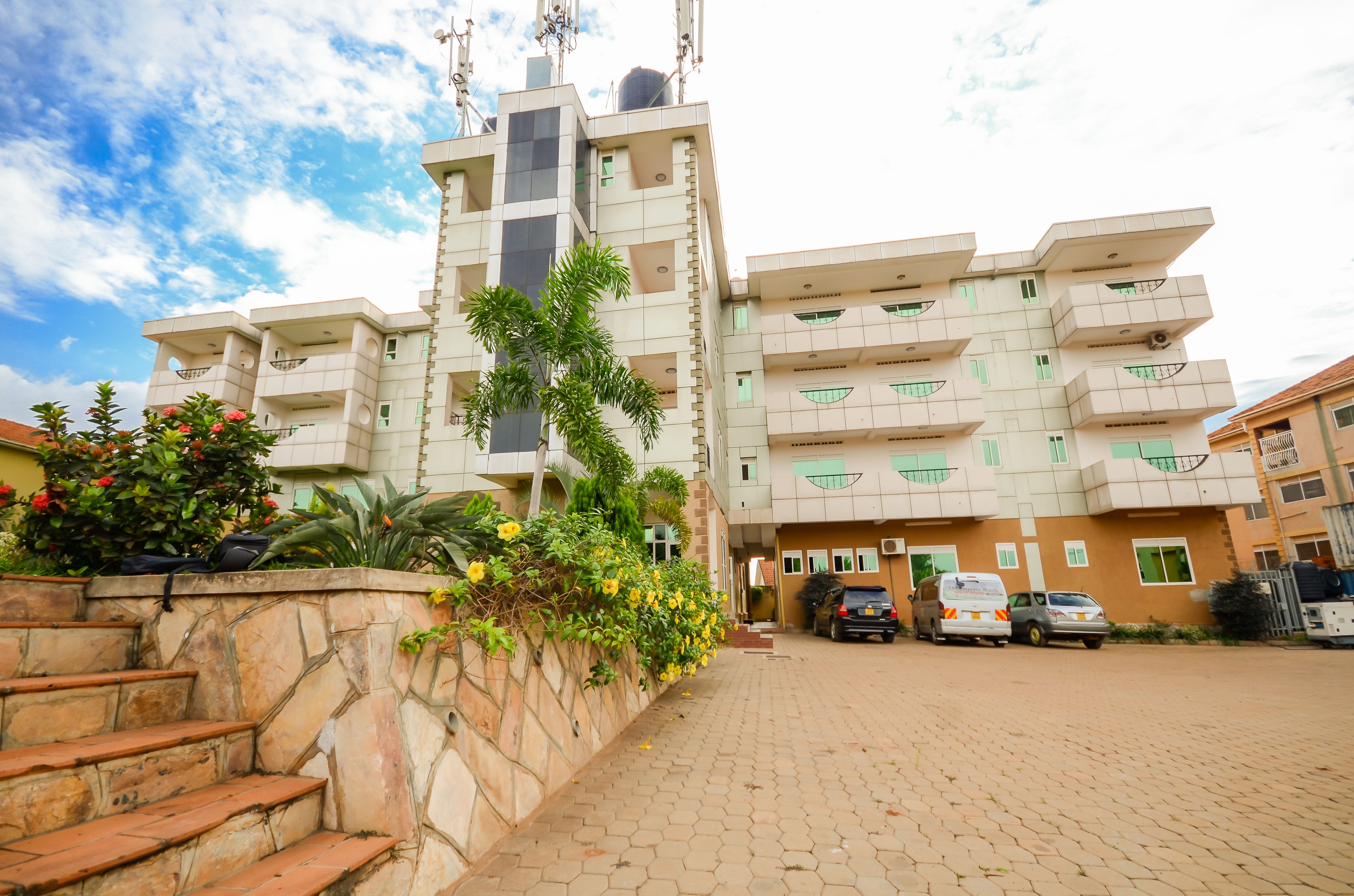 A multi-story residential building with a unique architectural design, featuring balconies and a stone staircase.