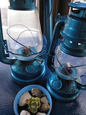 Two blue lanterns with transparent glass covers, one with a visible metal base and the other with a metal handle. - Zhimbad B&B by the sea (Capdepera)