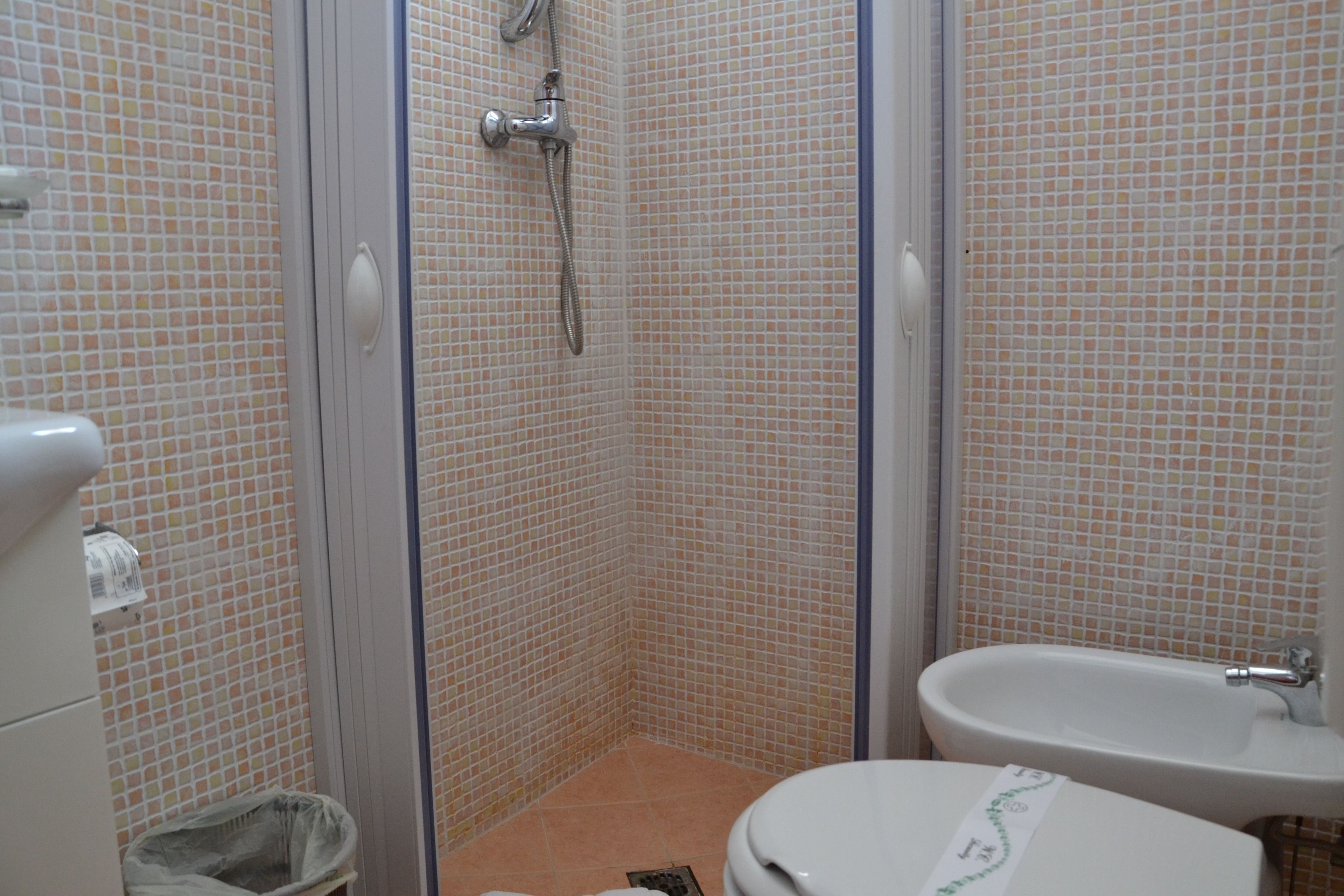 A bathroom with a shower, toilet, and sink.