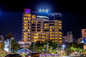 A multi-story hotel with illuminated signage and a prominent entrance. - Yamagata Kaku Hotel & Spa (Jiaoxi)