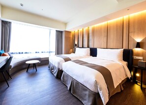 A modern hotel room with a large bed, a desk, and a view of the city. - Yamagata Kaku Hotel & Spa (Jiaoxi)