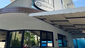 Un hotel moderno con fachada curva, grandes ventanales y una zona de acceso cubierta.