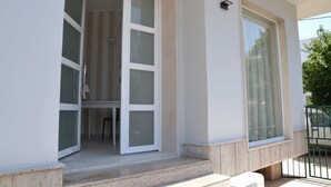 Una entrada de edificio moderna con puerta de cristal que da a un espacio interior.