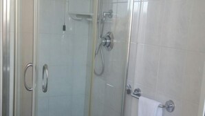 A glass-enclosed shower with a handheld showerhead and a wall-mounted faucet. - Hotel Astoria (Viareggio)