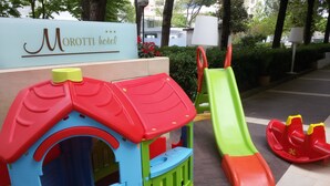 A children's play area with a slide and a playhouse. - Hotel Morotti (Misano Adriatico)