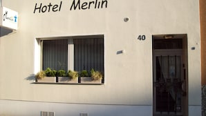 A building labeled "Hotel Merlin" with a window displaying plants. - Hotel Merlin (Cologne)