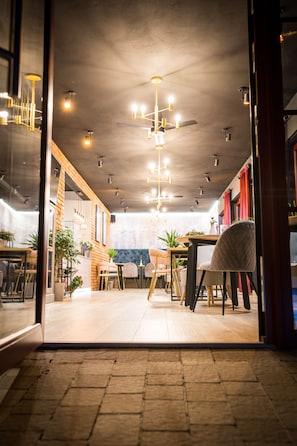 Enjoy meals in the dining area with a wooden table and chairs, surrounded by potted plants and natural light.