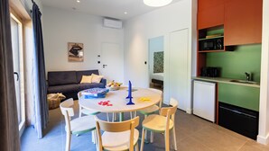 Een knus woongedeelte met een eethoek, kitchenette en een bank in de woonkamer.