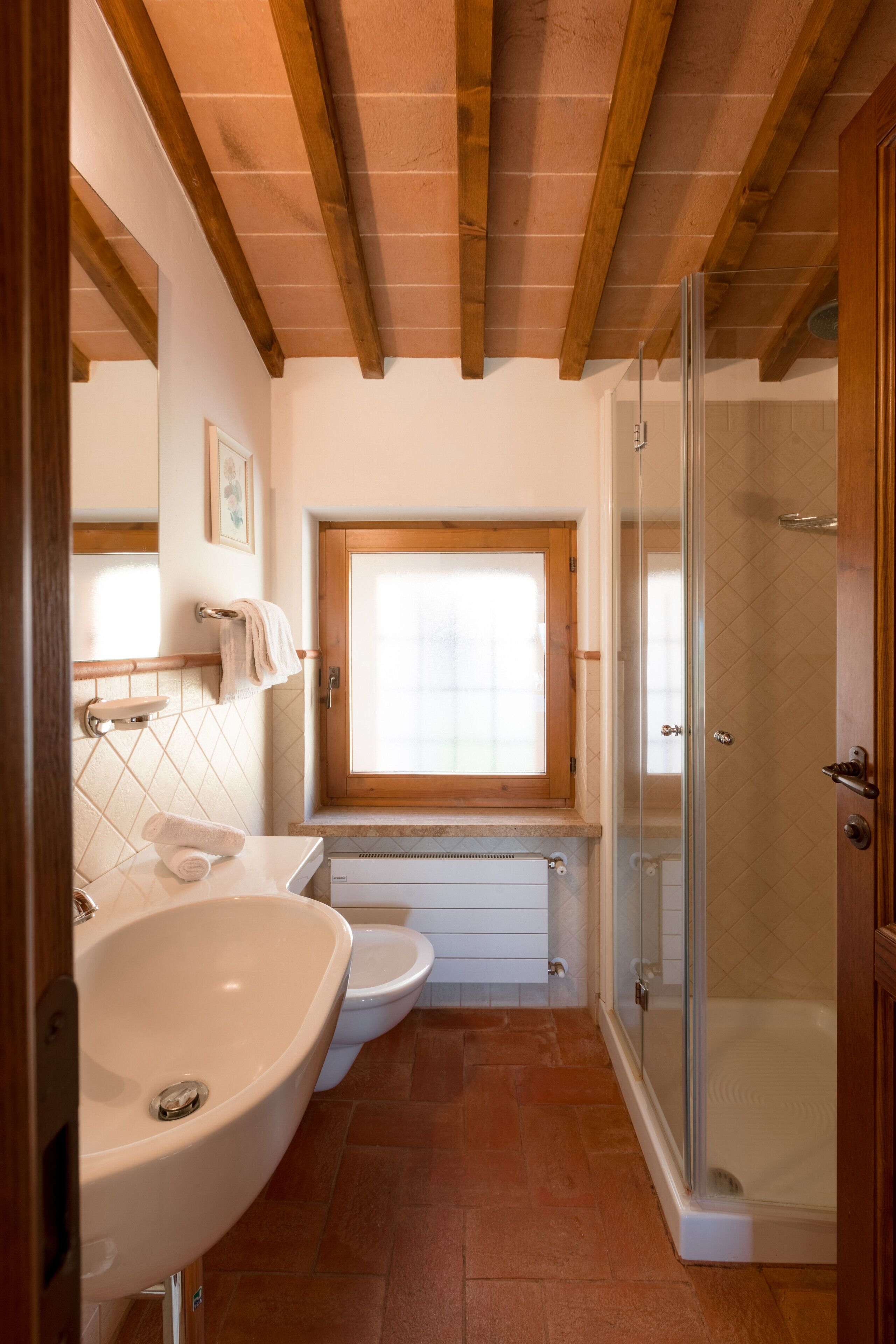 Un bagno con lavandino, WC e doccia.