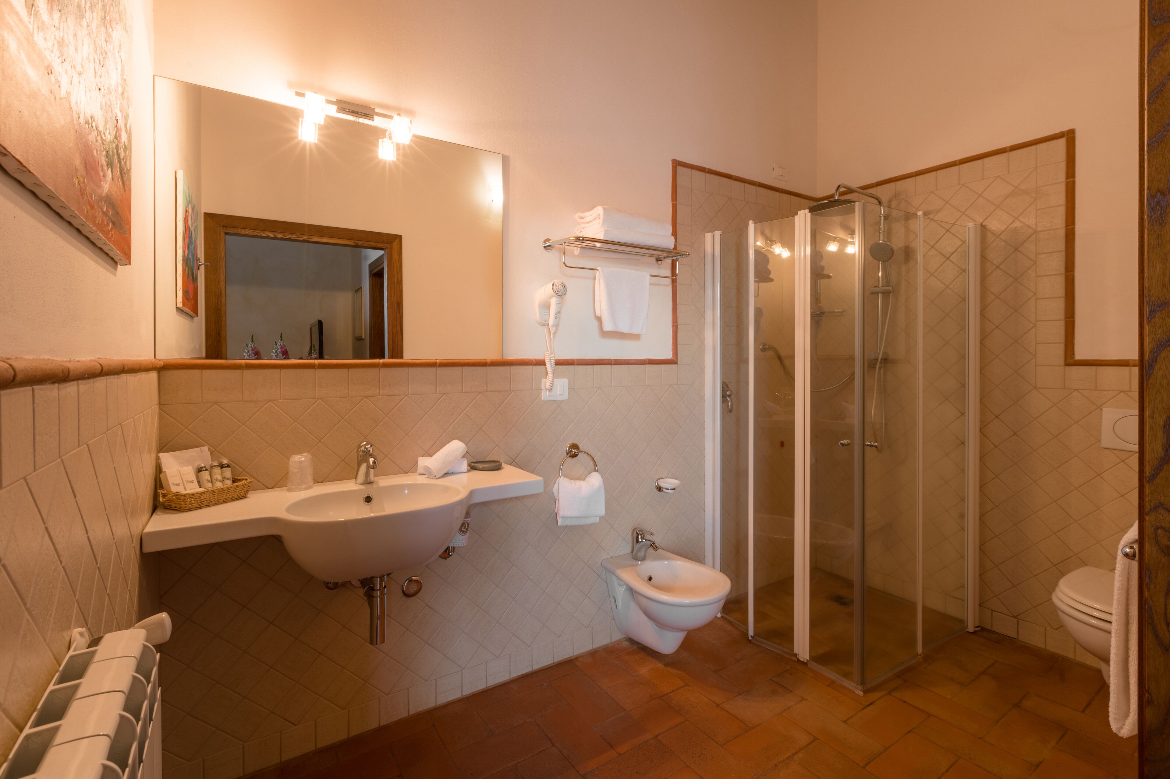 Un bagno moderno con lavandino, bidet e cabina doccia in vetro.