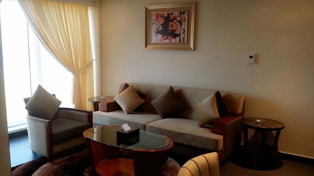 Una sala de estar con un sofá, dos sillones, una mesa de centro y una mesita auxiliar.