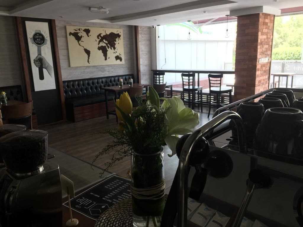 Un restaurant avec des banquettes en cuir noir, un moulin à café et une carte du monde accrochée au mur.