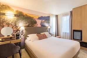A hotel room with a large bed, a desk with a computer, a TV, and a wall mural of a sunset landscape. - Best Western Hotel & SPA Coeur De Cassis (Cassis)
