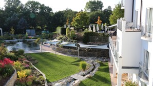 Un jardin bien entretenu, agrémenté d’un bassin, d’espaces aménagés pour s’asseoir et d’un sentier.