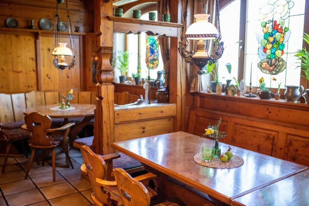 Un interior de madera con una mesa de comedor, sillas y un vitral.