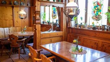 Un interior de madera con una mesa de comedor, sillas y un vitral.