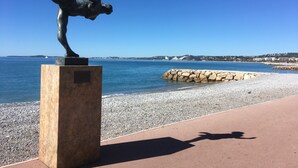 A statue of a figure in a dynamic pose on a pedestal by the seaside. - MOTEL ASCOT - Hôtel & Appartements (Cagnes-sur-Mer)