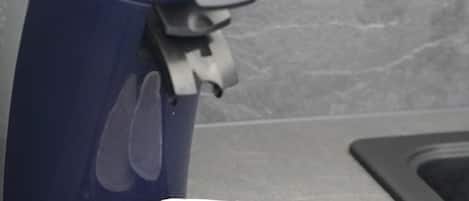 Una cafetera azul con un solo portavasos sobre una encimera.