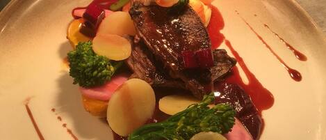 Un plato de comida con varias verduras y un trozo de carne.
