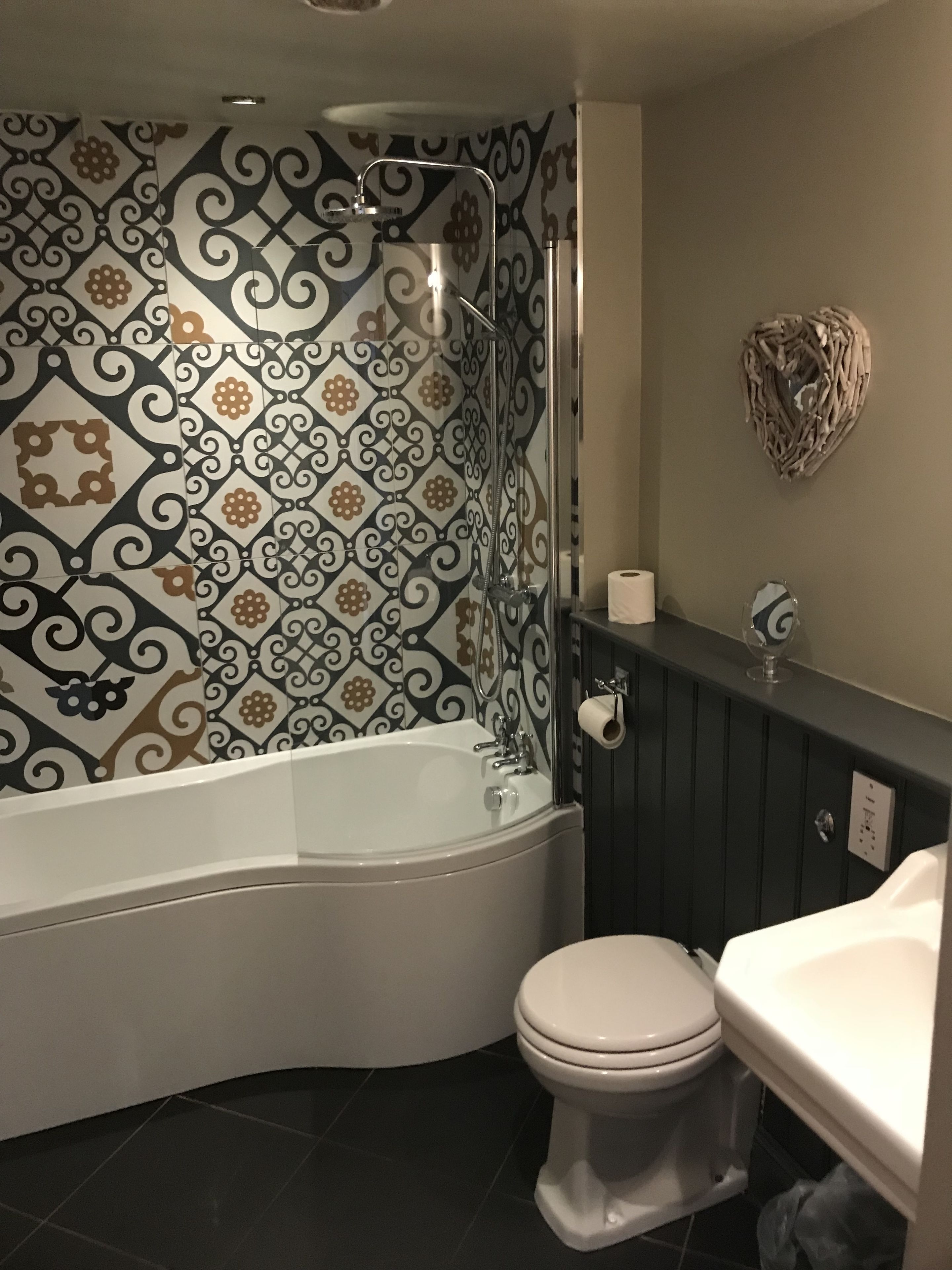 A bathroom with a freestanding bathtub, a toilet, and a vanity with a mirror.
